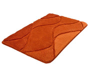 Der Badteppich FIONA Chili 60 x 100 cm liegt flach und zeigt ein orangerotes Wellenmuster.