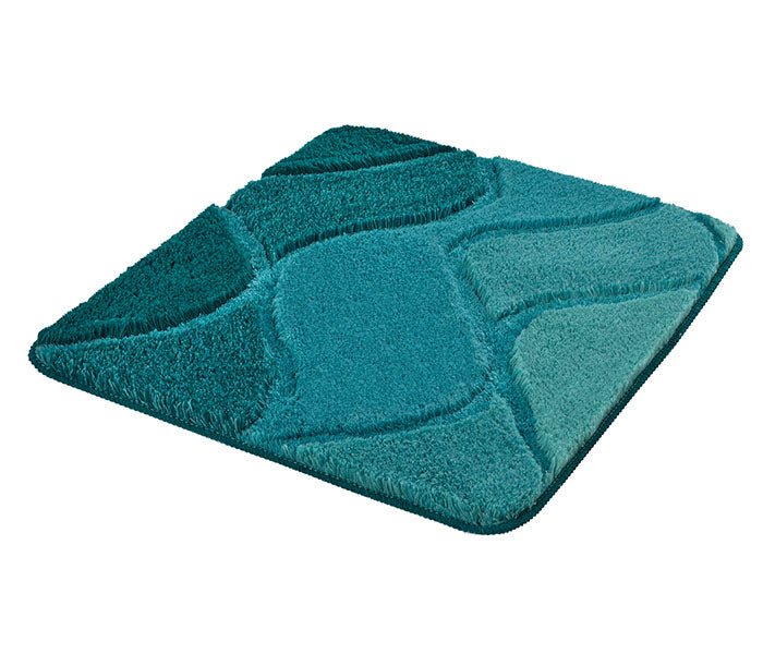 Badteppich FIONA in Petrol 55 x 65 cm mit reliefartigem Wellenmuster liegt auf dem Boden.