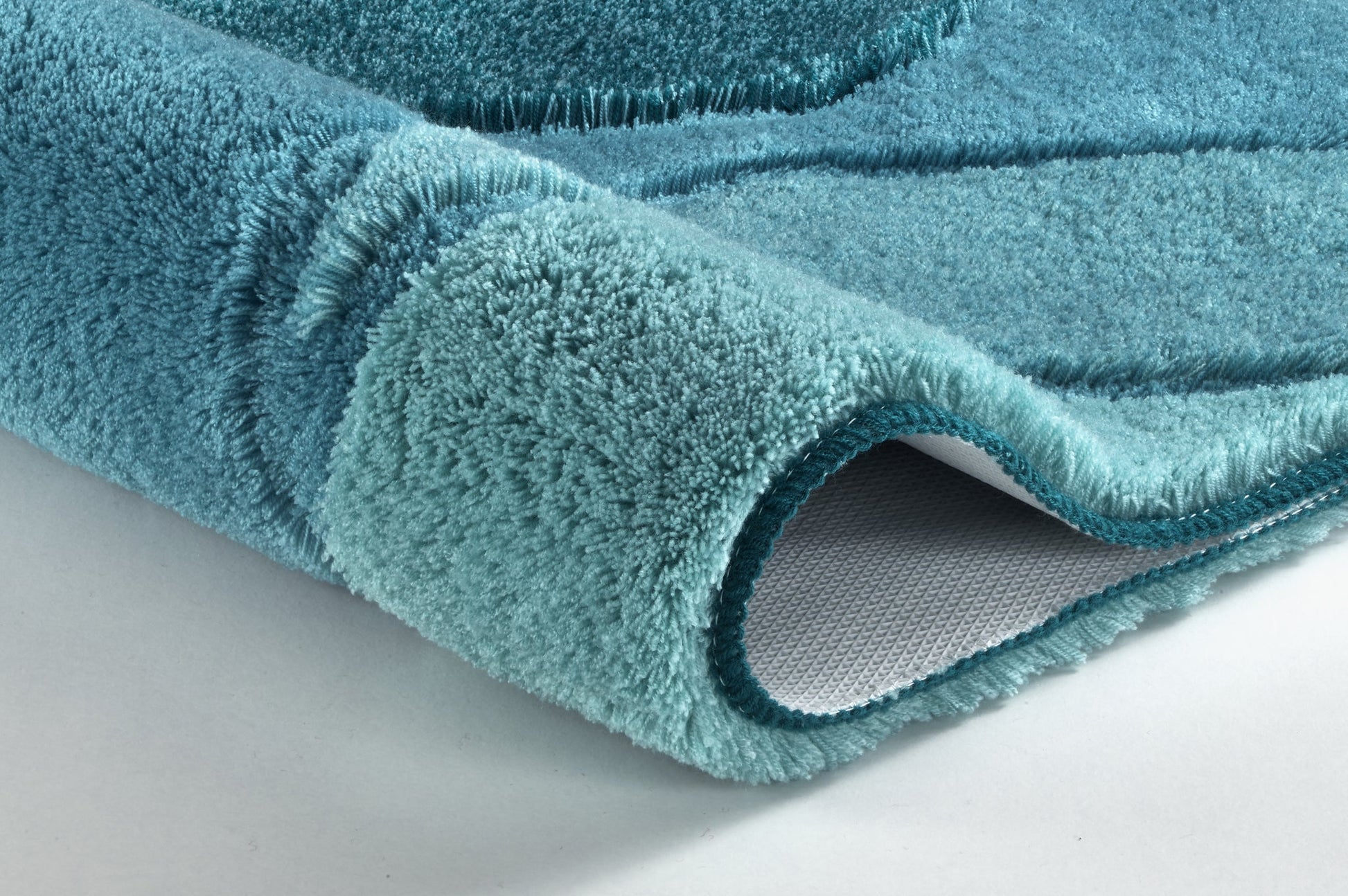 Nahaufnahme des Badteppichs FIONA in Petrol, 70 x 120 cm, mit weichem Flor und rutschhemmender Rückseite.
