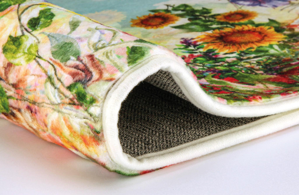 Aufgerollter Badteppich mit buntem Blumenmuster und sichtbarer Unterseite.