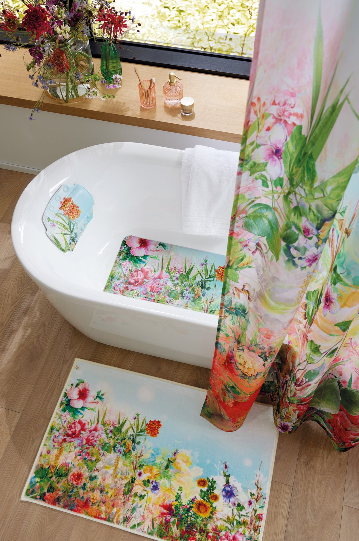 Bad mit floralem Duschvorhang, Wanne und buntem Badteppich.