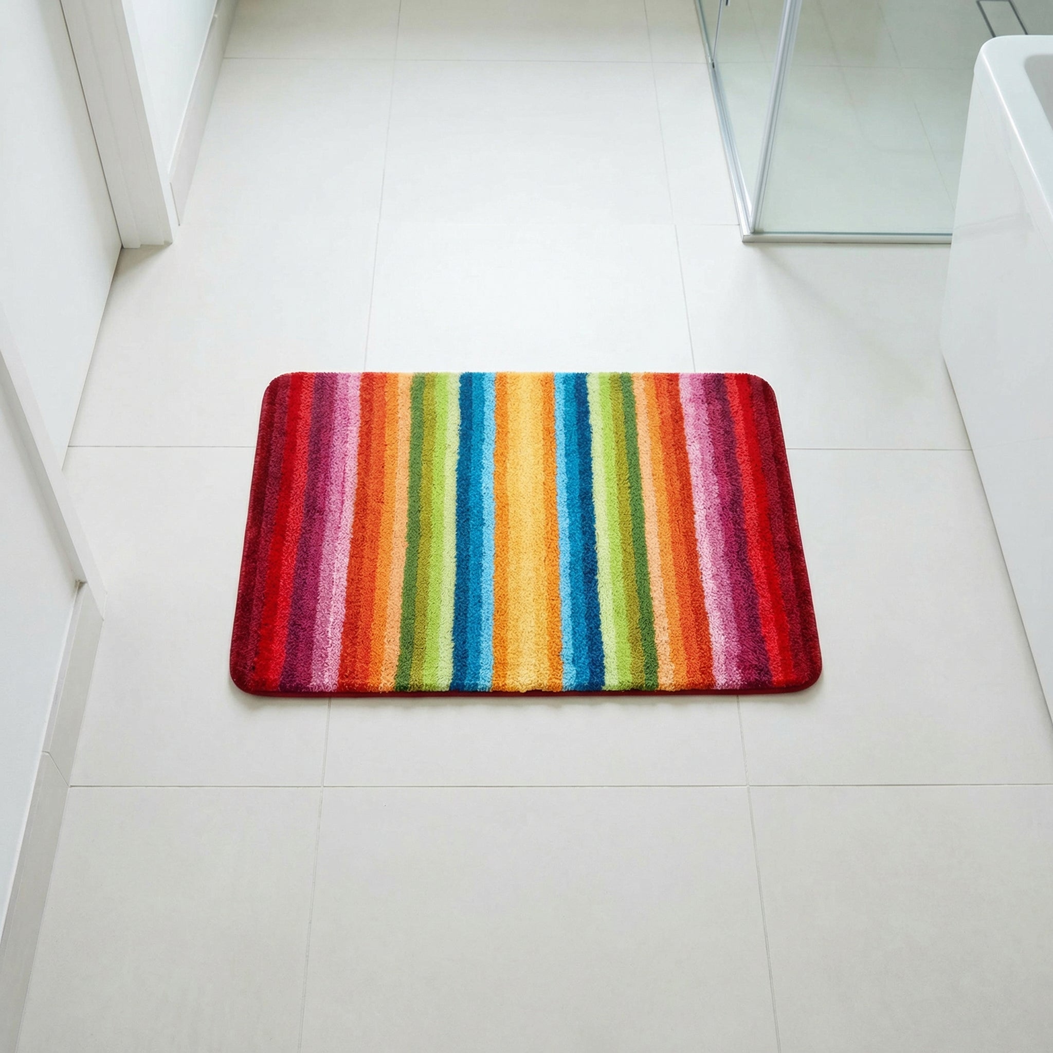 Bunter rechteckiger Badteppich mit bunten Streifen auf Fliesenboden