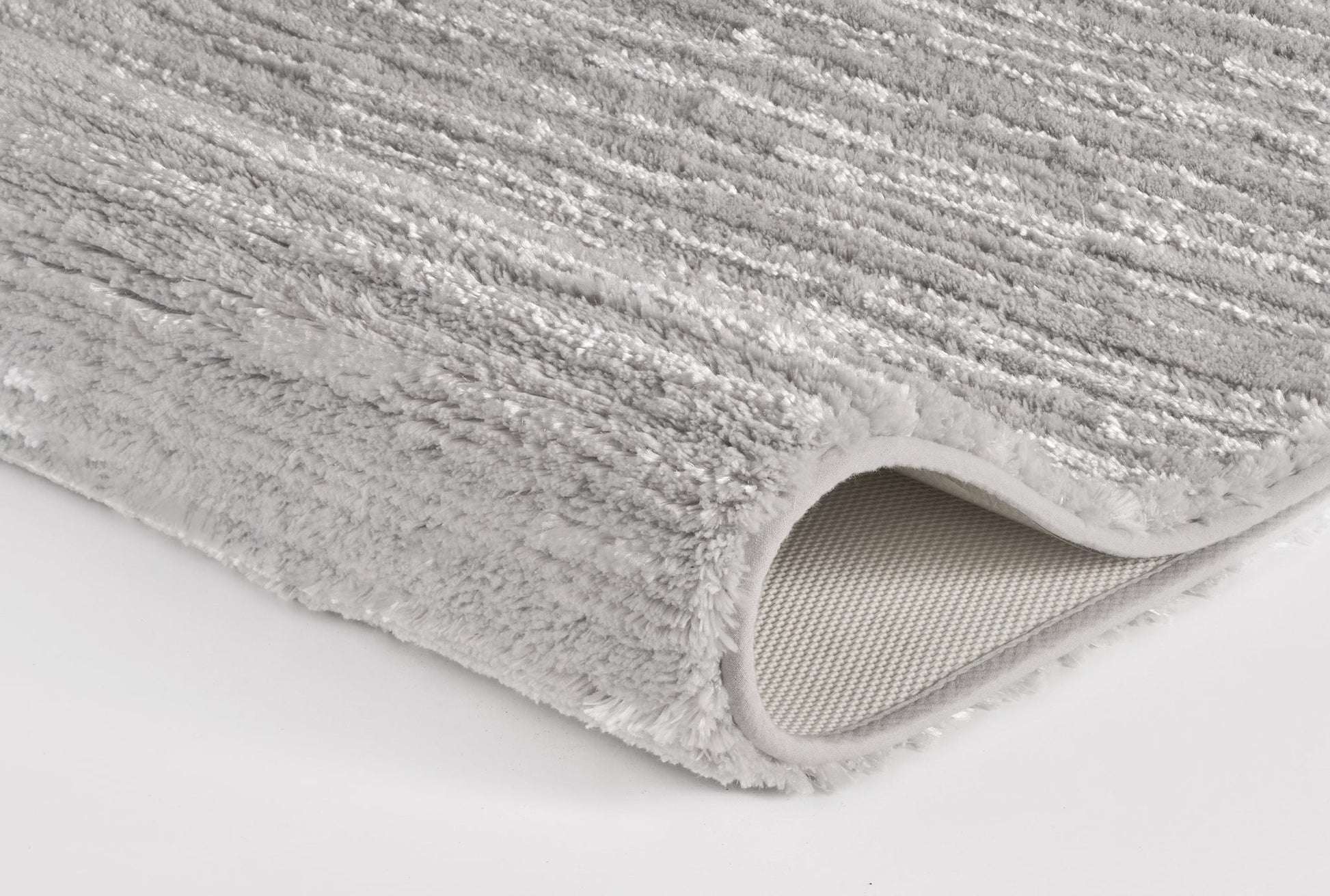 Detailansicht eines weichen, grauen Badteppichs mit rutschfester Rückseite