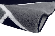 Nahaufnahme einer grauen Badematte mit weiß-schwarzem Streifenmuster