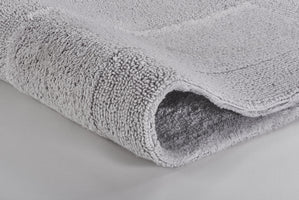 Hellgraue, weiche Badematte mit dichter Hochflor-Struktur in Nahaufnahme