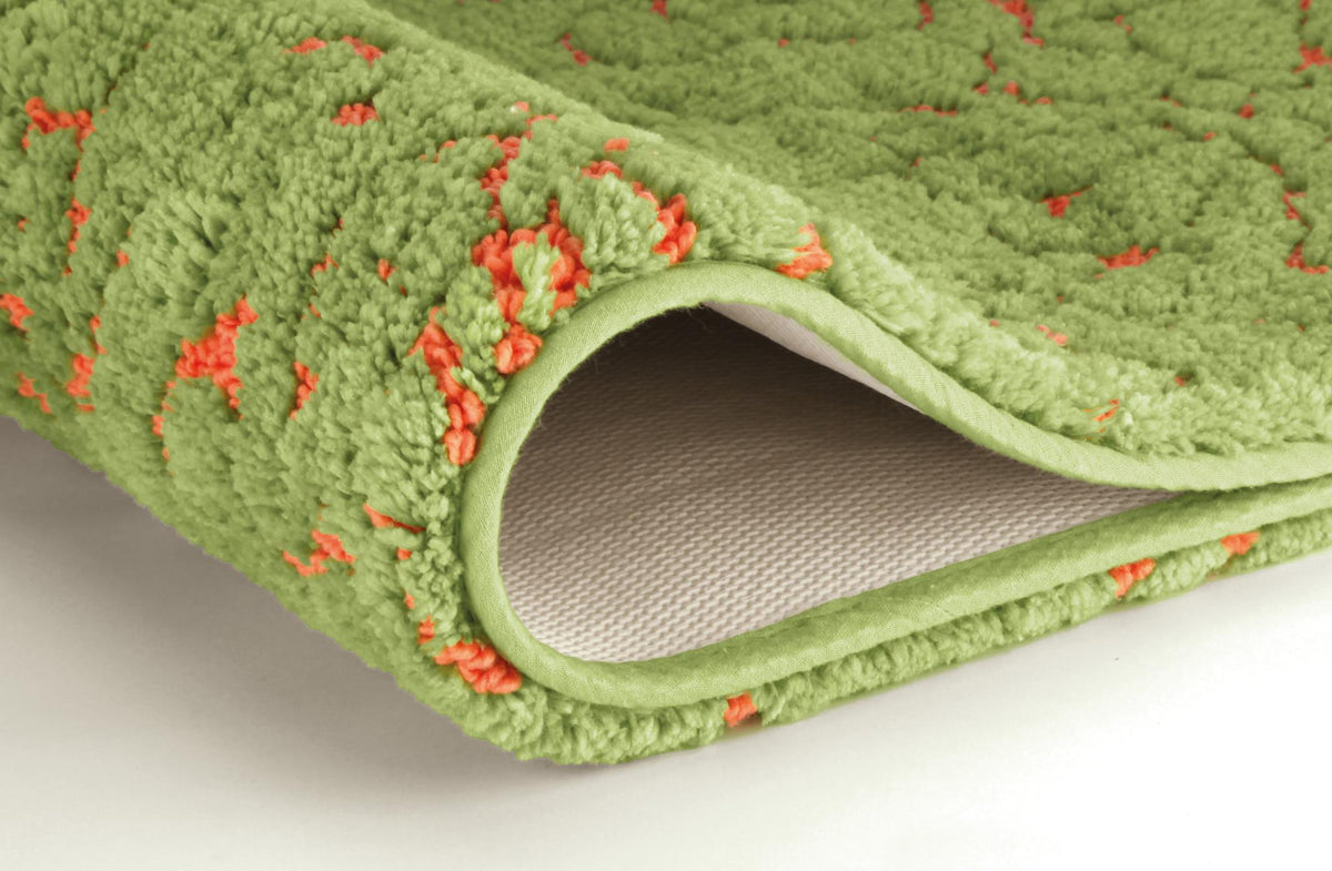 Grüner Badteppich mit orangefarbenem Muster, gefaltet im Detail.