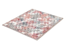 Flauschiger Teppich in Rosa, Grau und Weiß mit strukturierter Oberfläche.