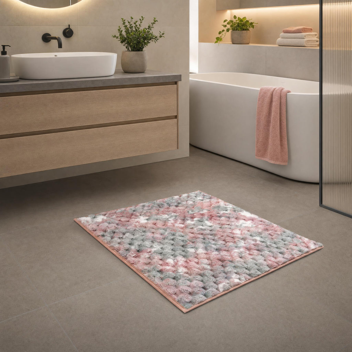 Flauschiger rosa-grauer Badteppich in modernem Badezimmer vor Badewanne.