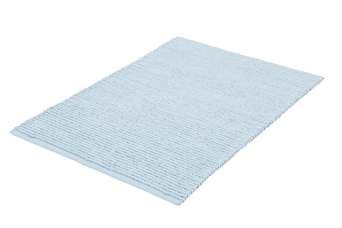Hellblauer gerippter Badteppich in rechteckiger Form auf weißem Grund.
