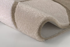 Nahaufnahme beigefarbene Badematte mit Streifen und rutschfester Unterseite