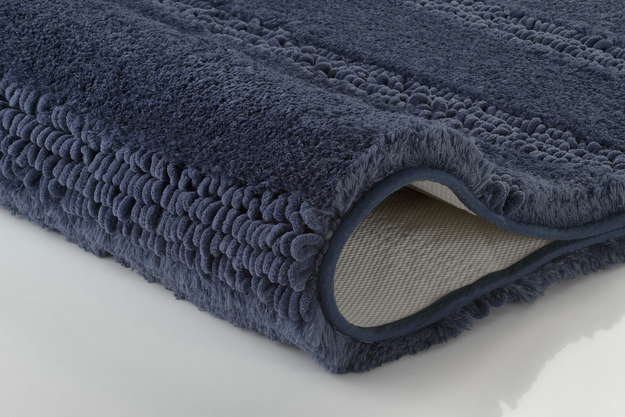 Dunkelblaue Badematte aus weichem Hochflor in seitlicher Nahaufnahme