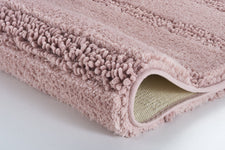 Rosa Badteppich mit hoher, flauschiger Struktur in Nahaufnahme gezeigt