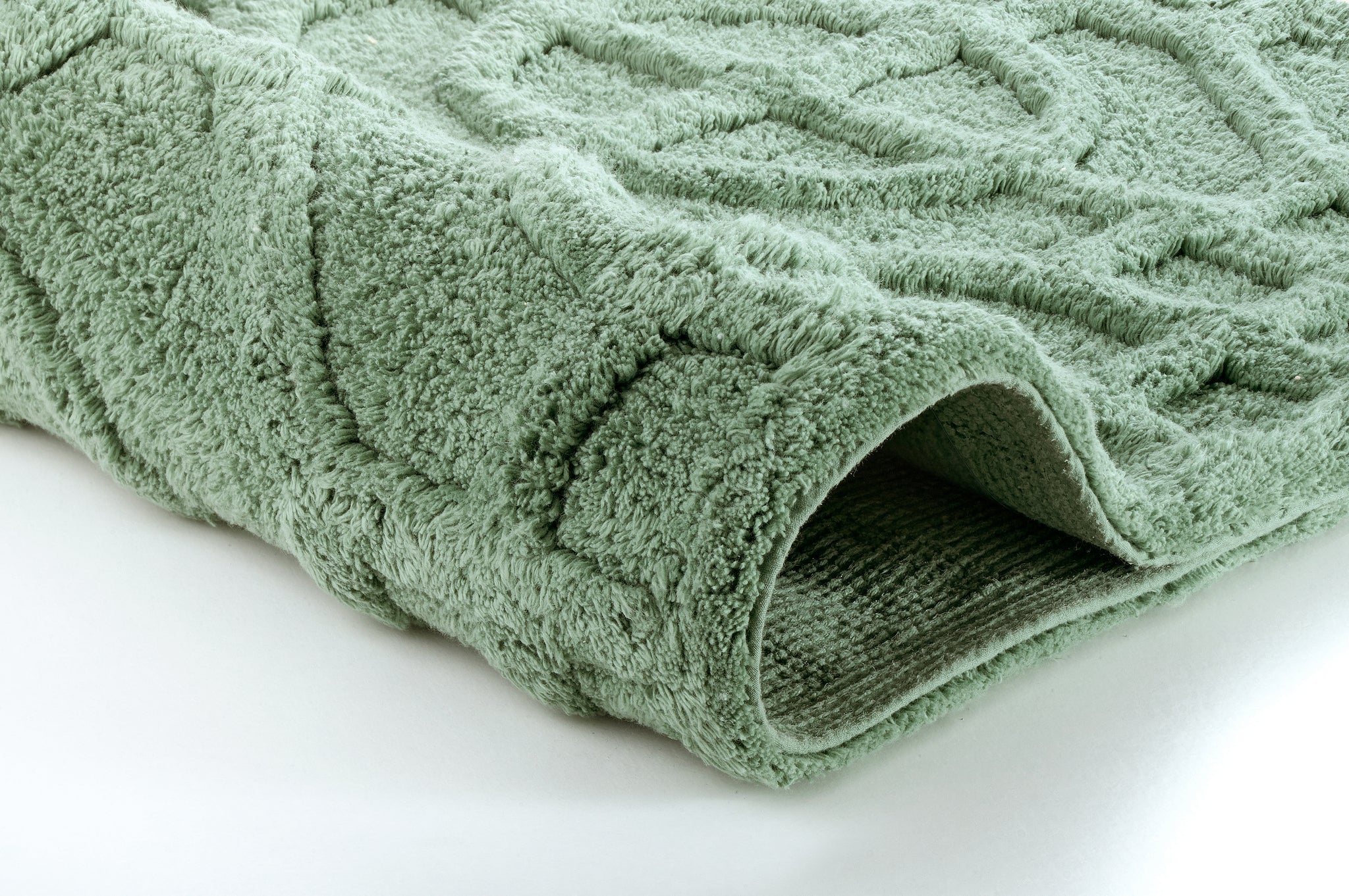 Nahaufnahme einer grünen Badematte mit weicher Hoch-Tief-Struktur