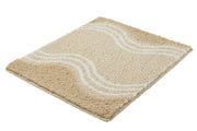Badteppich MOVE Sandbeige 50 x 60 cm mit wellenförmigem Muster liegt auf dem Boden.
