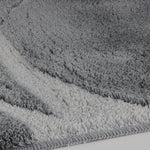 Nahaufnahme eines grauen Badteppichs mit weichem, dichtem Flor