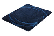 Rechteckiger Badteppich MYSTIC Navy 55 x 65 cm mit dunkelblauem Kreis-Design liegt auf weißem Untergrund.