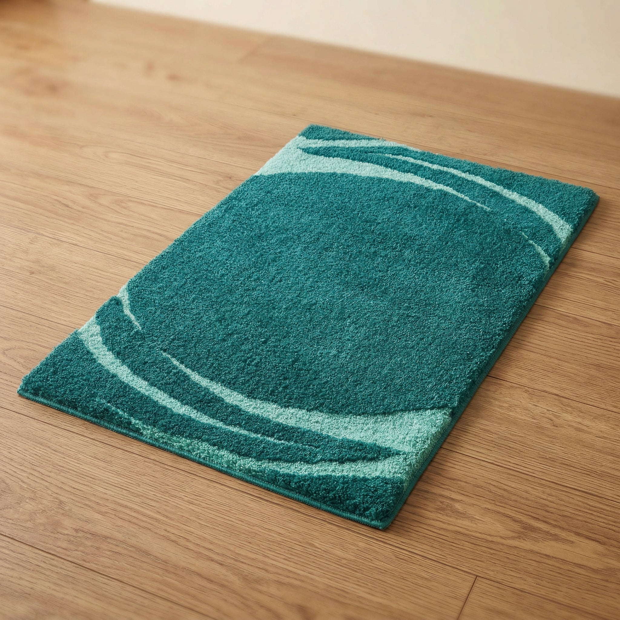 Türkiser, rechteckiger Badteppich mit hellen Wellen auf Holzboden