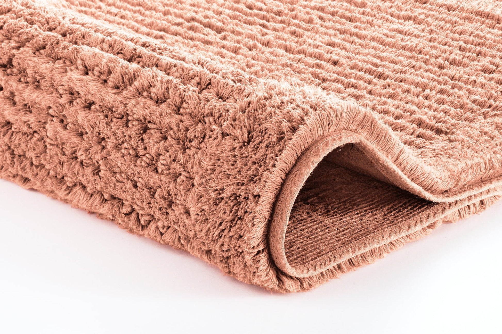 Badteppich NET Papaya 80 x 140 cm liegt gefaltet und zeigt seine weiche, strukturierte Oberfläche.