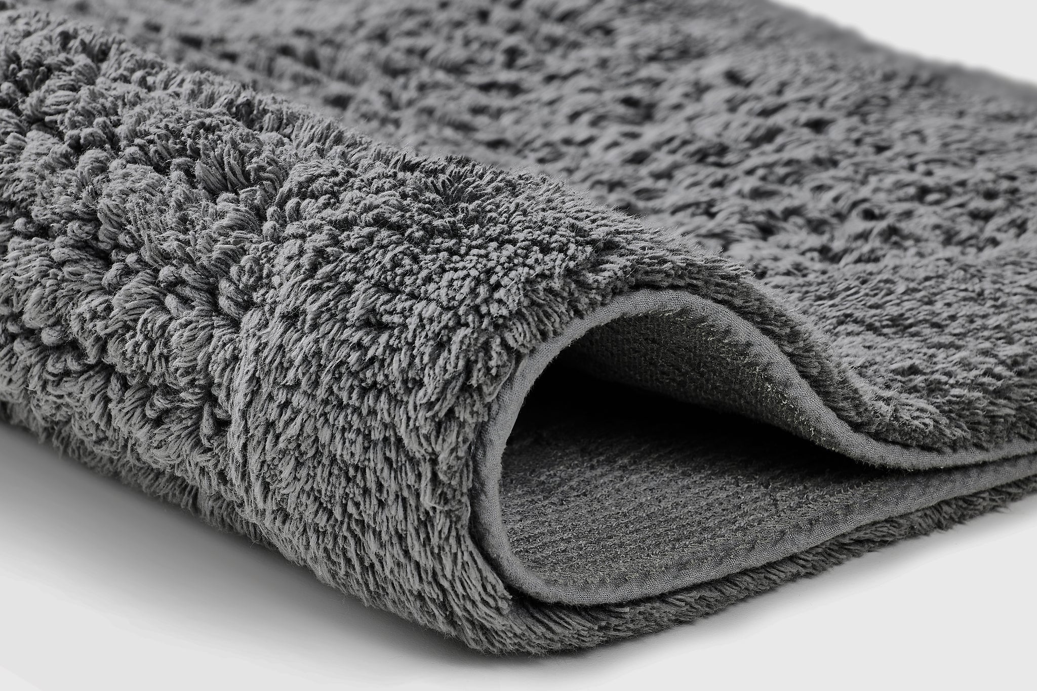 Nahaufnahme vom Badteppich NET Schiefer 80 x 140 cm mit weicher, strukturierter Oberfläche.