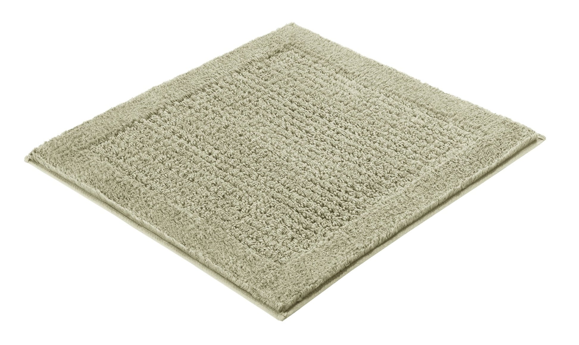 Rechteckiger Badteppich NET in Farbe Schilf mit Strukturfläche liegt auf hellem Untergrund.