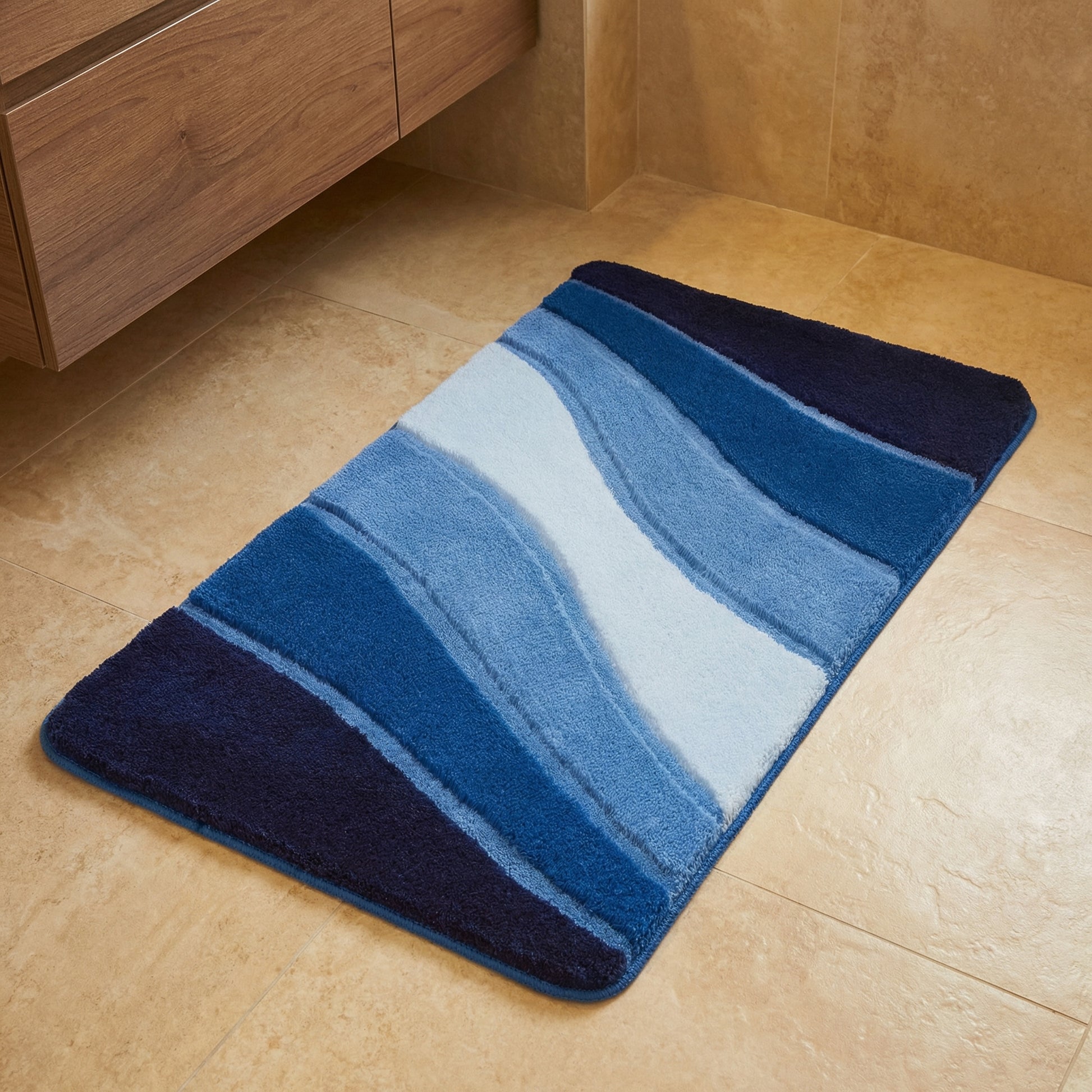 Blaue rechteckige Badematte mit Wellenmuster auf beigem Fliesenboden