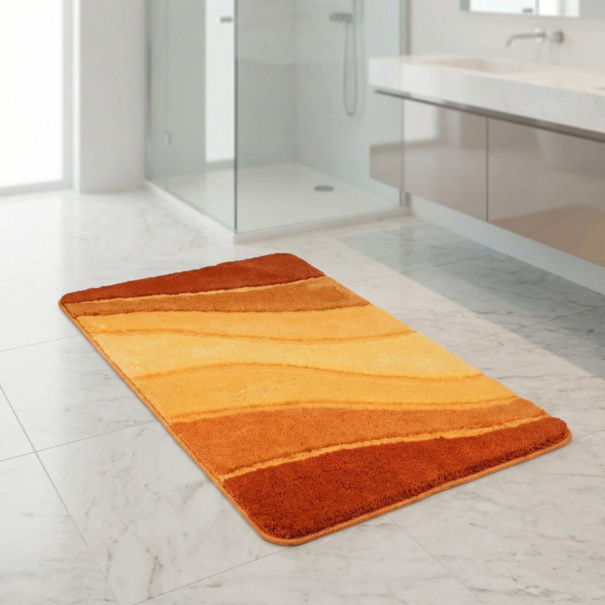Orange-gelber Badteppich mit Wellenmuster auf weißem Marmorboden im Bad
