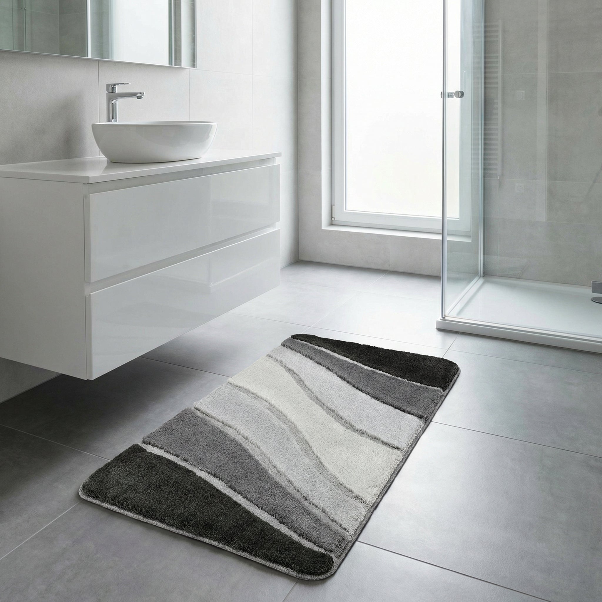 Grauer Badteppich mit Streifen vor weißem Waschbecken und Dusche