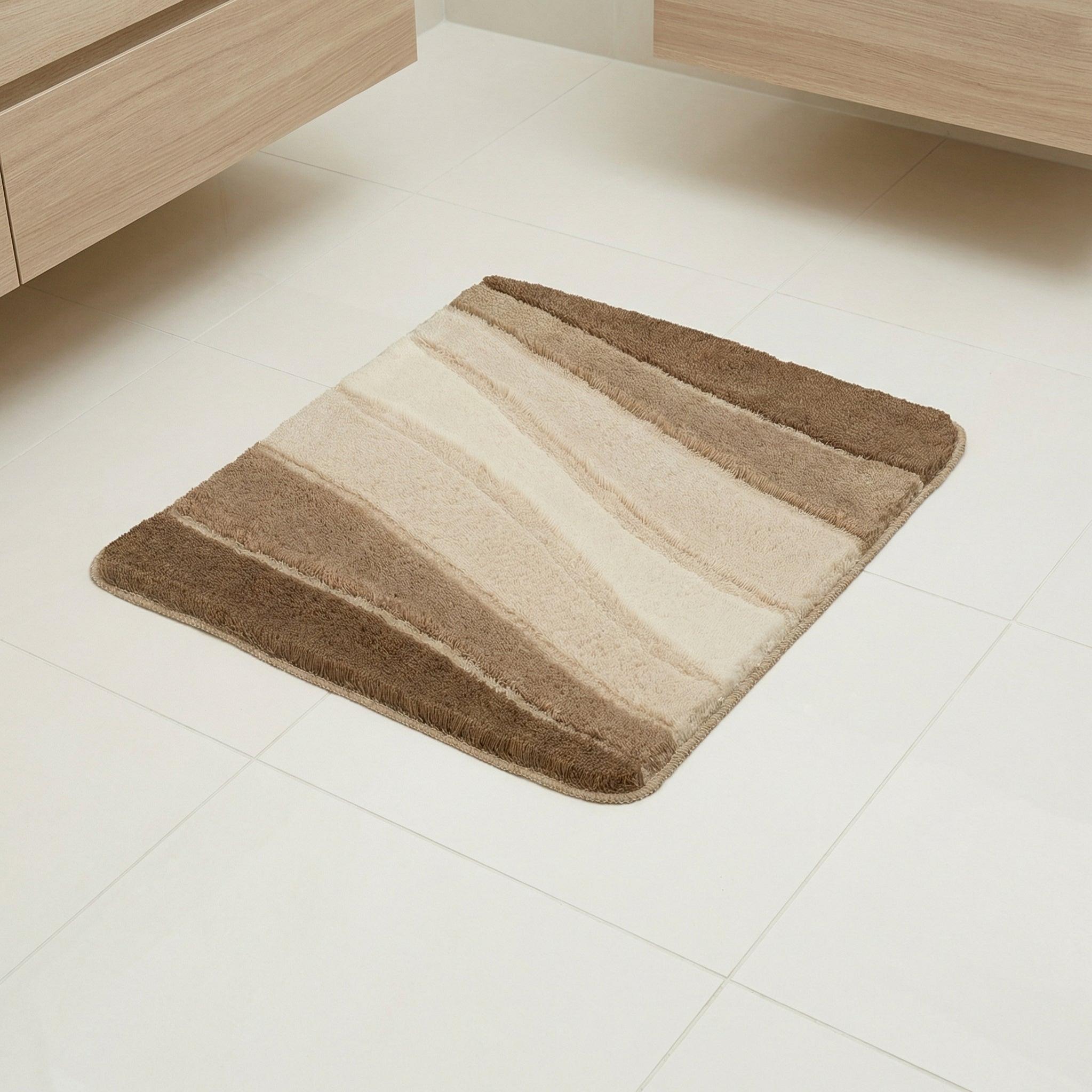 Quadratische Badematte in Beige- und Brauntönen auf hellen Fliesen