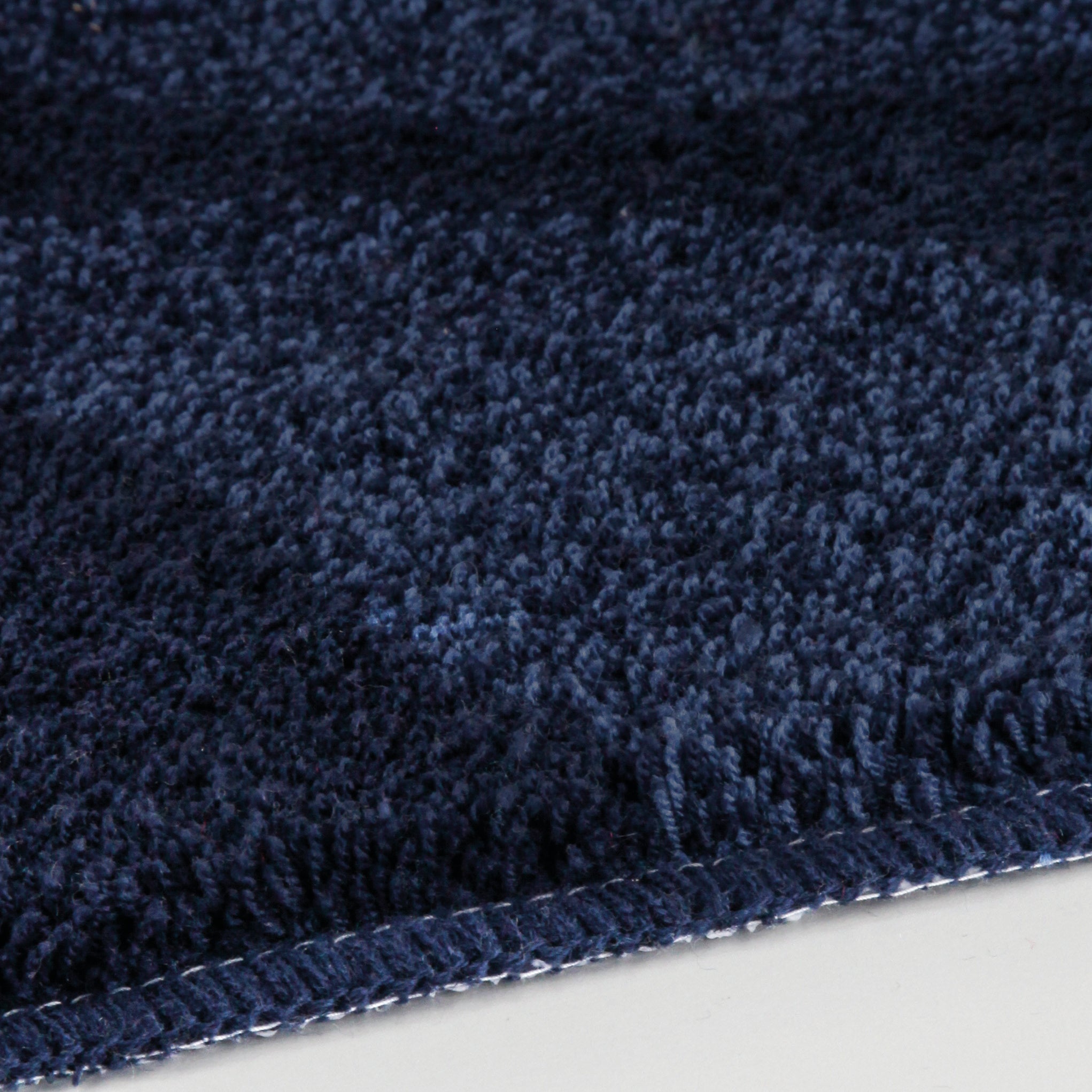 Detailansicht Badteppich ONDA Navy 60 x 90 cm mit dichter, dunkelblauer Oberfläche.