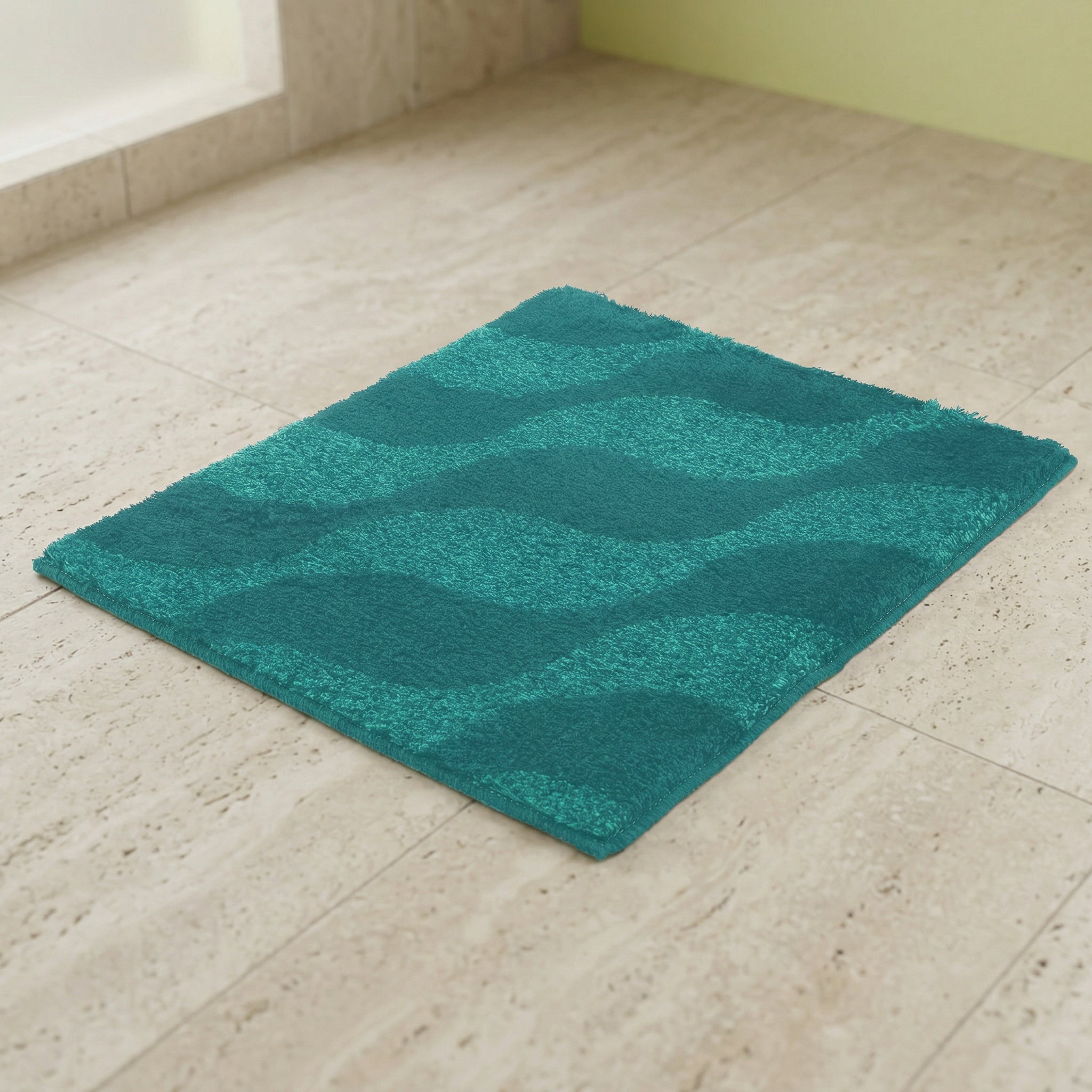 Türkisfarbener Badteppich mit wellenförmigem Muster auf Fliesenboden