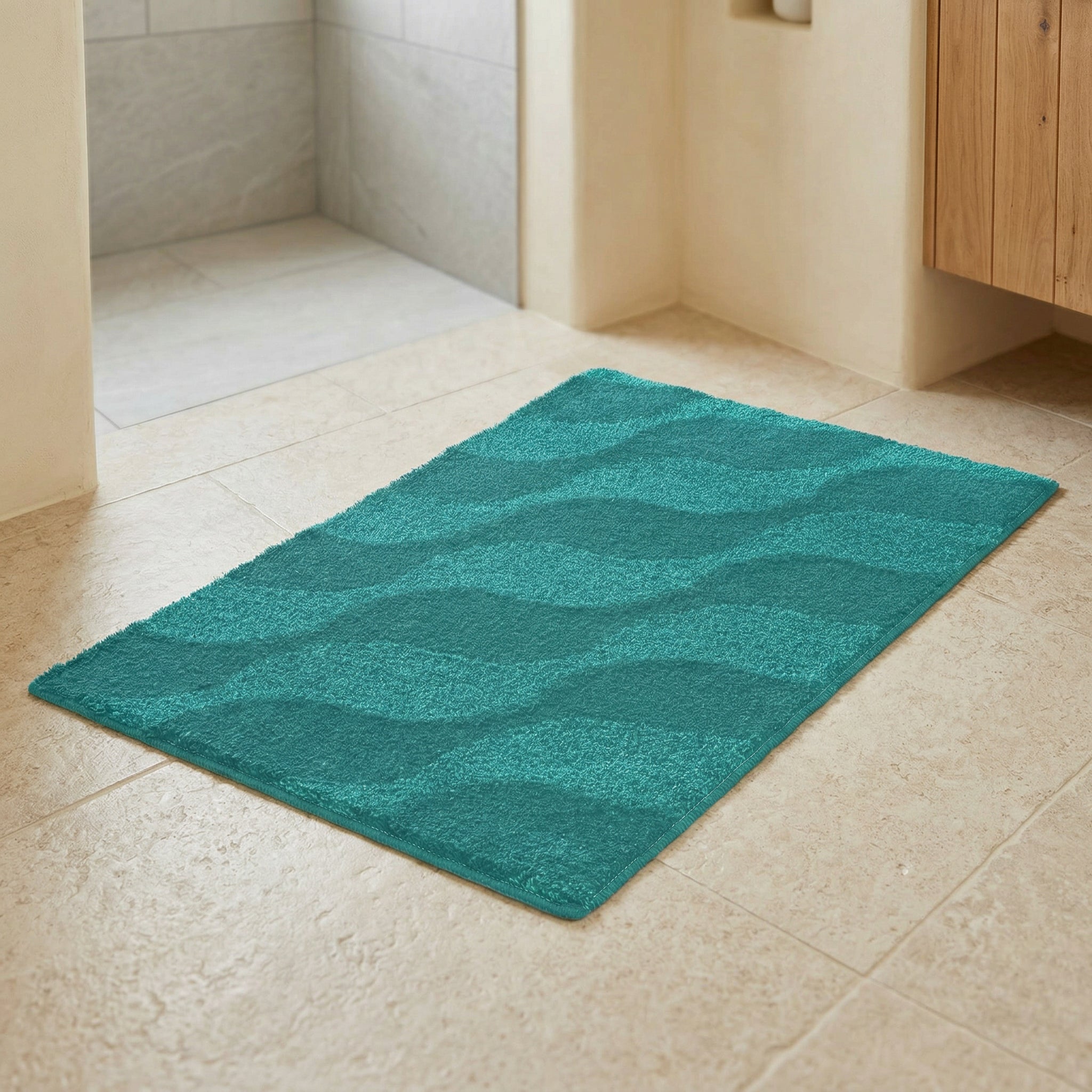 Türkise Badematte mit Wellenmuster auf hellem Fliesenboden im modernen Bad