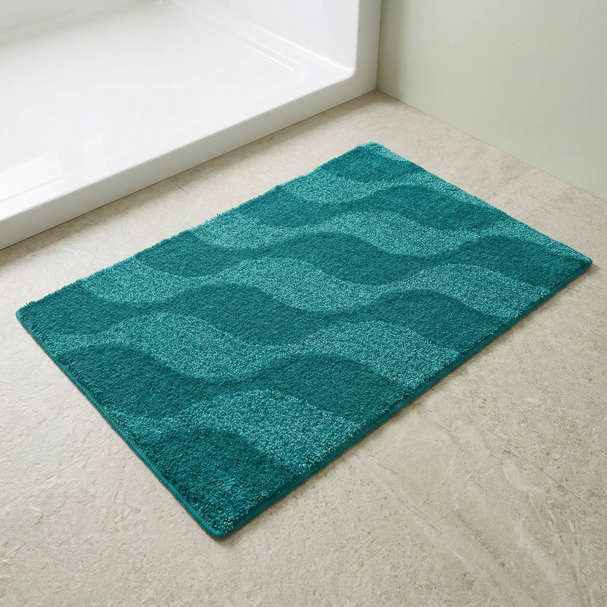 Große türkisfarbene Badematte mit Wellenmuster auf hellem Fliesenboden