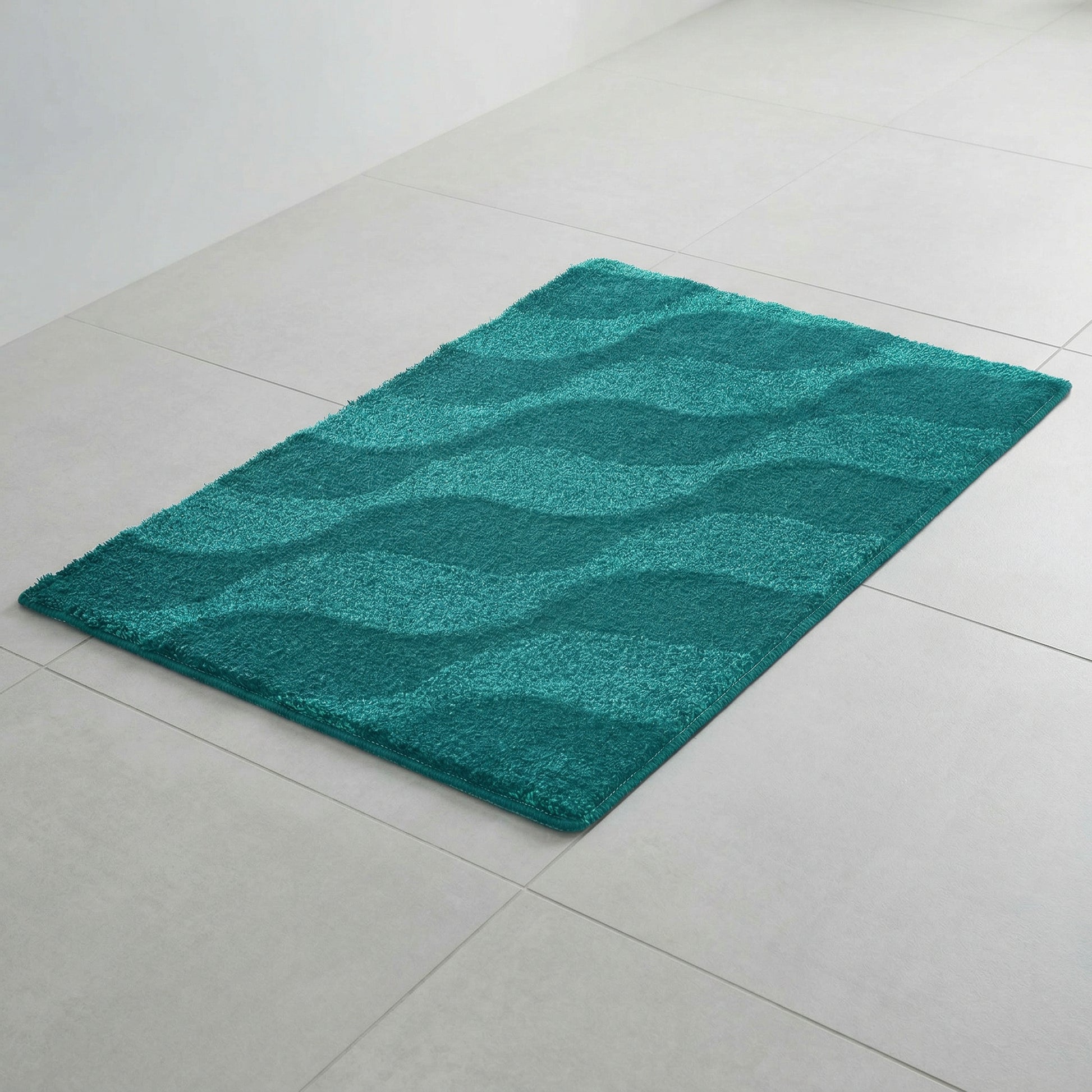 Türkisfarbener Badematte mit Wellenmuster auf hellen Fliesenboden