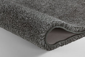 Graue, dicke Badematte in Nahaufnahme mit strukturierter Rückseite