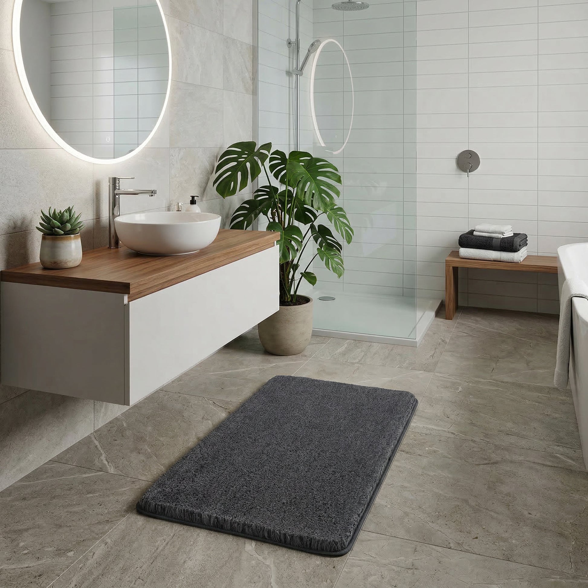 Dunkelgrauer Badteppich auf Fliesen im modernen Bad vor Dusche und Waschtisch
