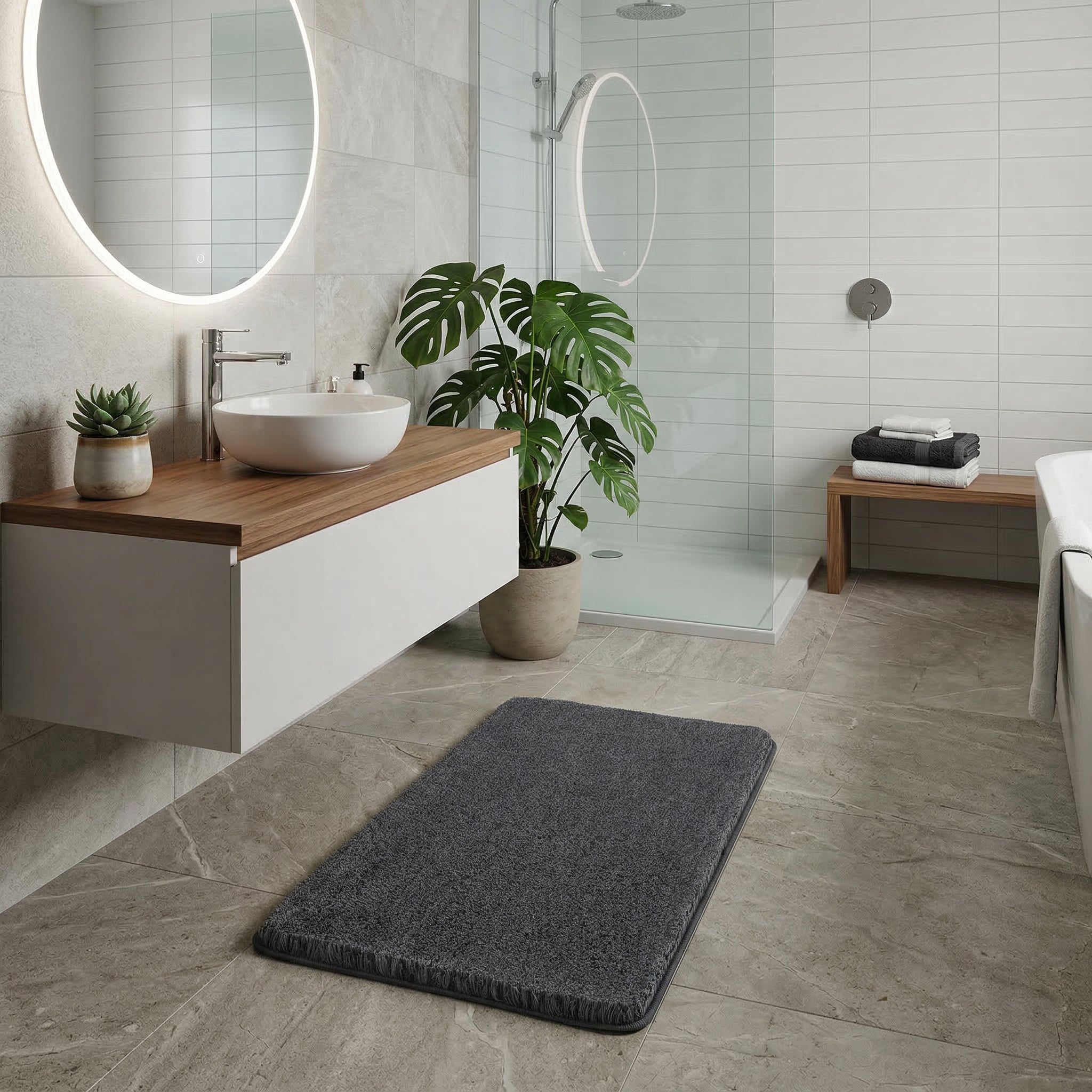 Dunkelgrauer Badteppich auf Fliesen im modernen Bad vor Dusche und Waschtisch