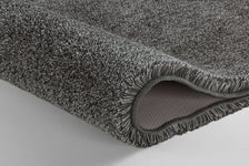 Detailansicht einer grauen Badematte mit sichtbarer rutschfester Unterseite