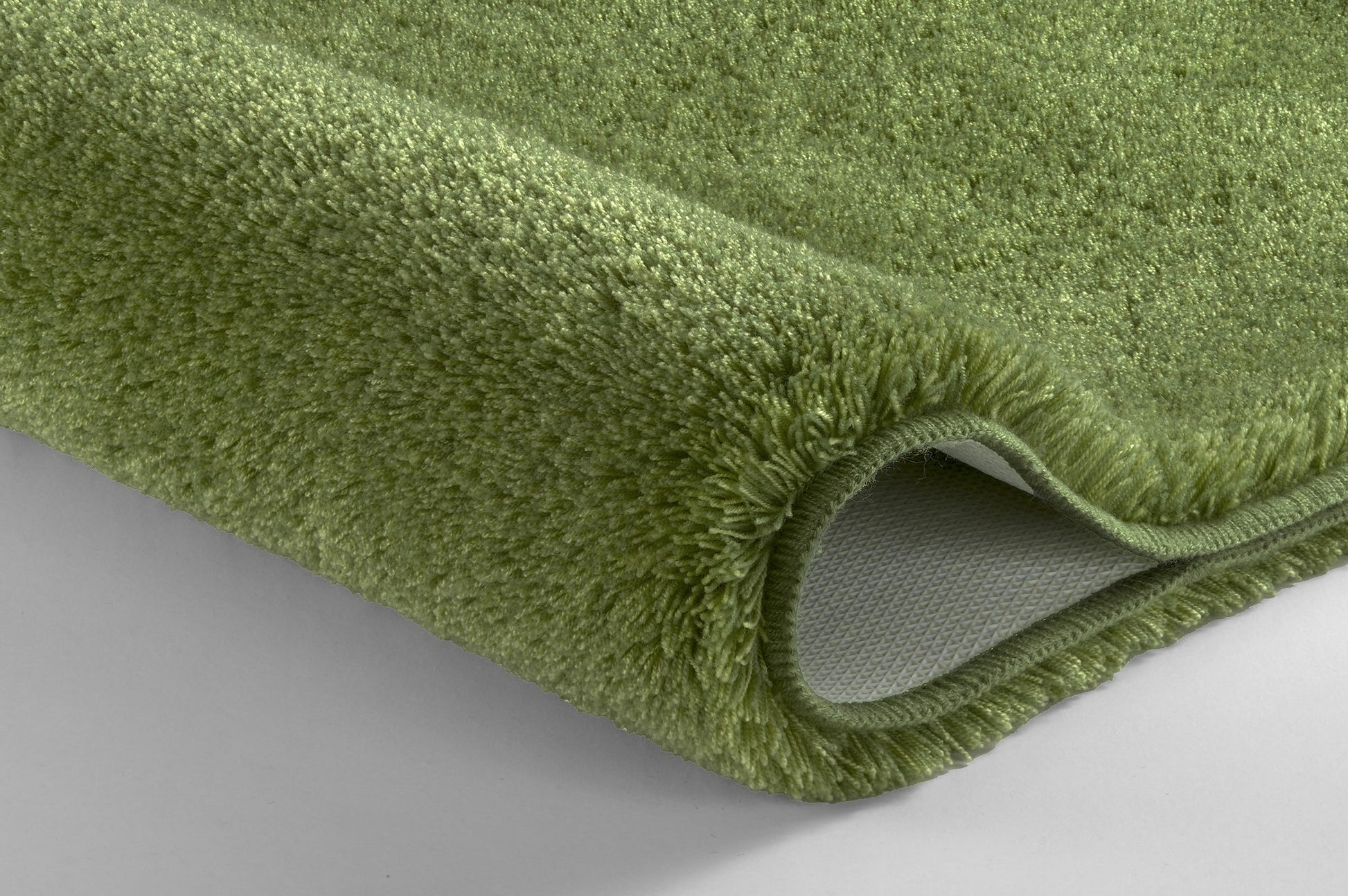 Nahaufnahme des grünen Badteppichs RELAX Forest 100 cm rund mit sichtbarer Teppichkante.