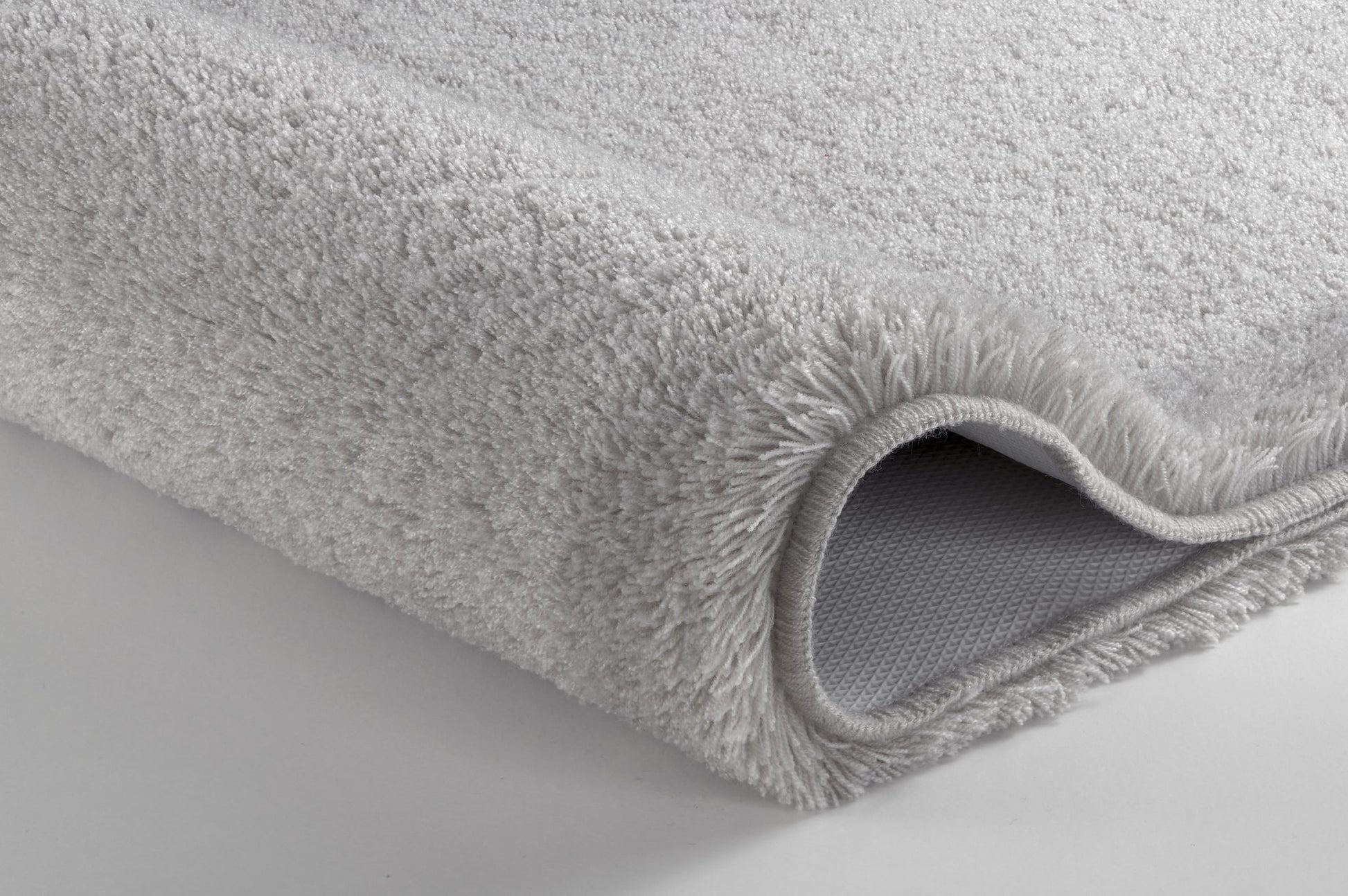 Badteppich RELAX Grau rund mit weichem Flor und rutschhemmender Rückseite liegt auf hellem Boden.