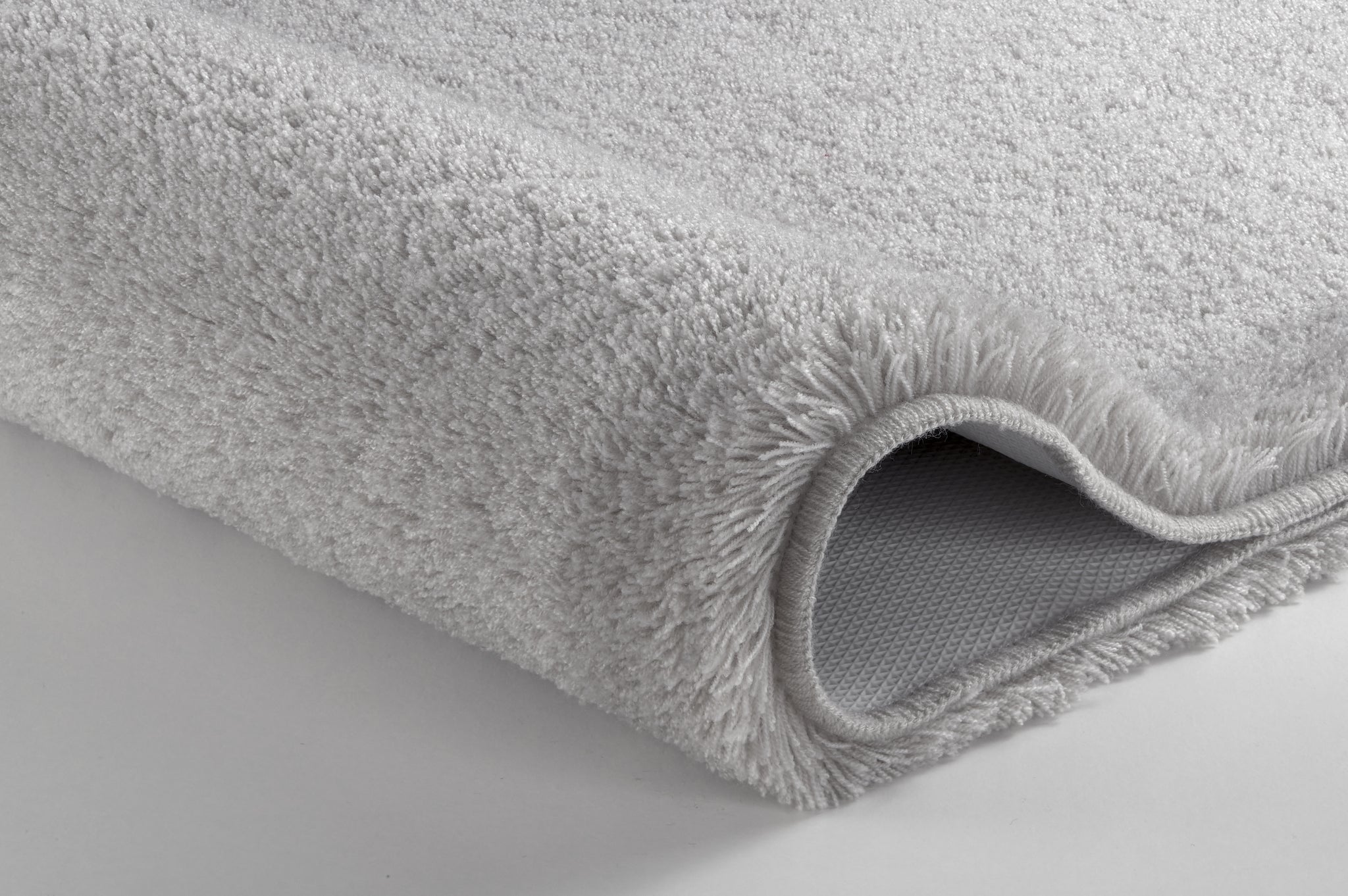 Badteppich RELAX Grau rund mit weichem Flor und rutschhemmender Rückseite liegt auf hellem Boden.