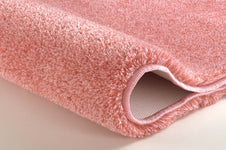 Nahaufnahme eines rosa Badteppichs mit weichem, hochflorigem Flor