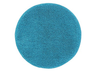 Runder, flauschiger Badteppich in leuchtendem Türkis von oben fotografiert