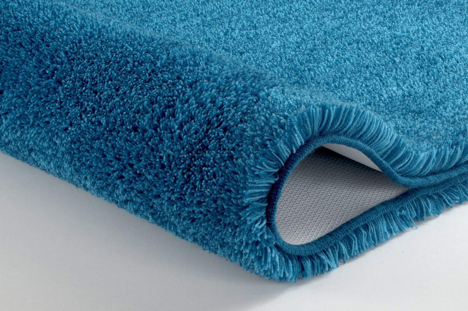 Badteppich RELAX Pazifik 100 cm rund in Nahaufnahme mit blauem, hohem Flor auf rutschhemmender Rückseite.