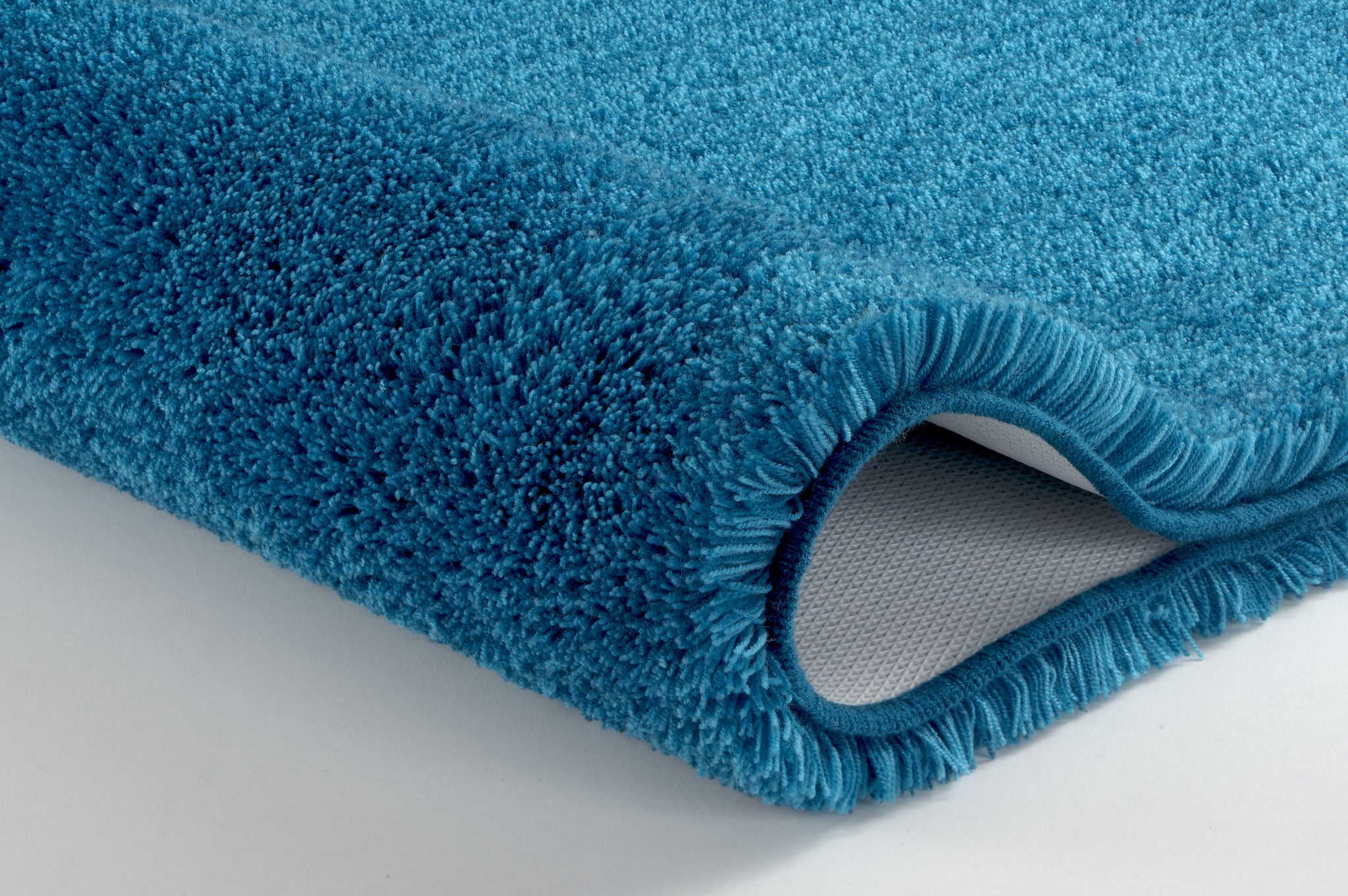 Badteppich RELAX Pazifik 100 cm rund in Nahaufnahme mit blauem, hohem Flor auf rutschhemmender Rückseite.