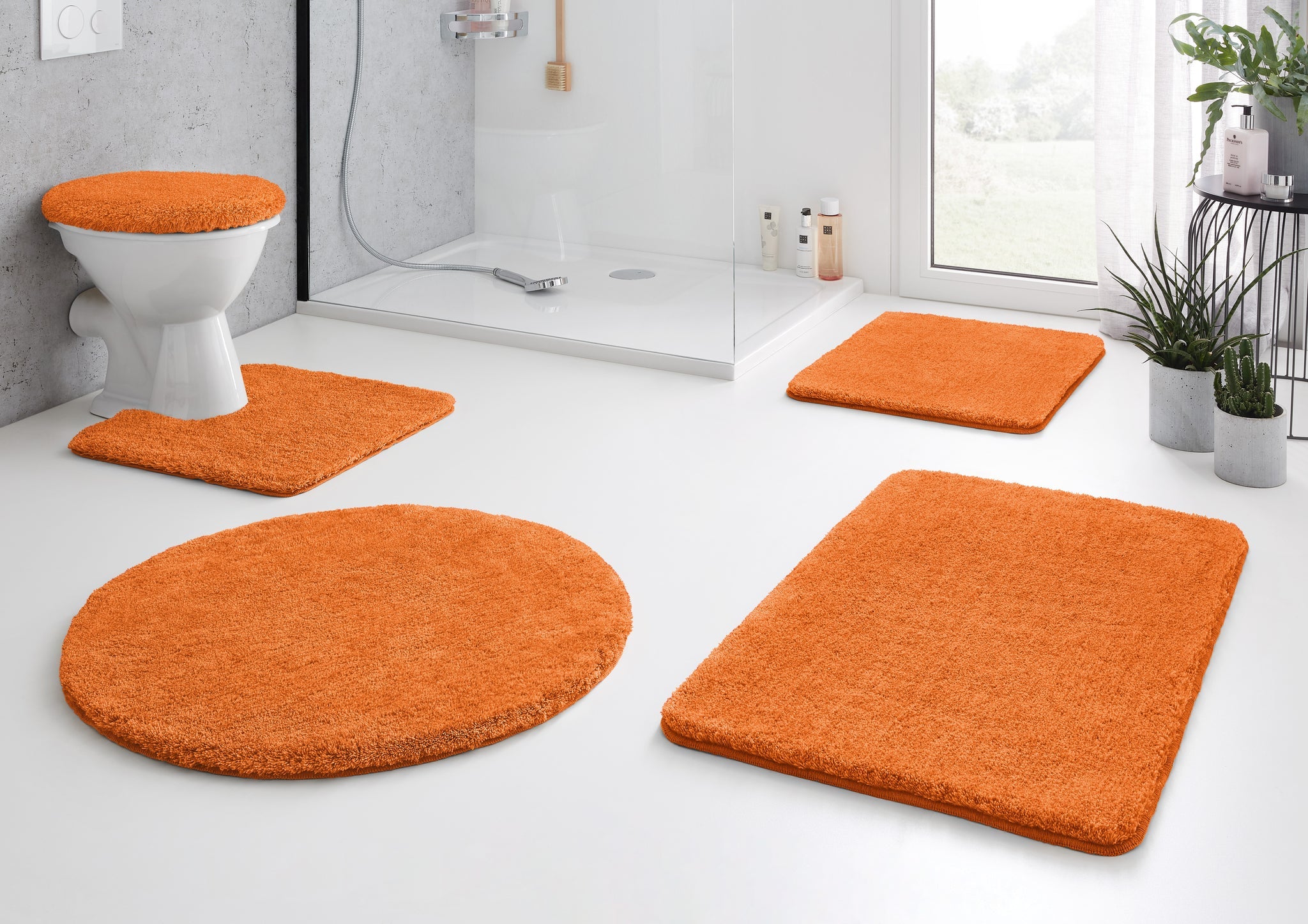 Orange Badteppiche und WC-Deckelbezug in modernem, hellem Bad mit Dusche