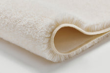 Nahaufnahme eines cremefarbenen, weichen Handtuchs, gefaltet am Rand