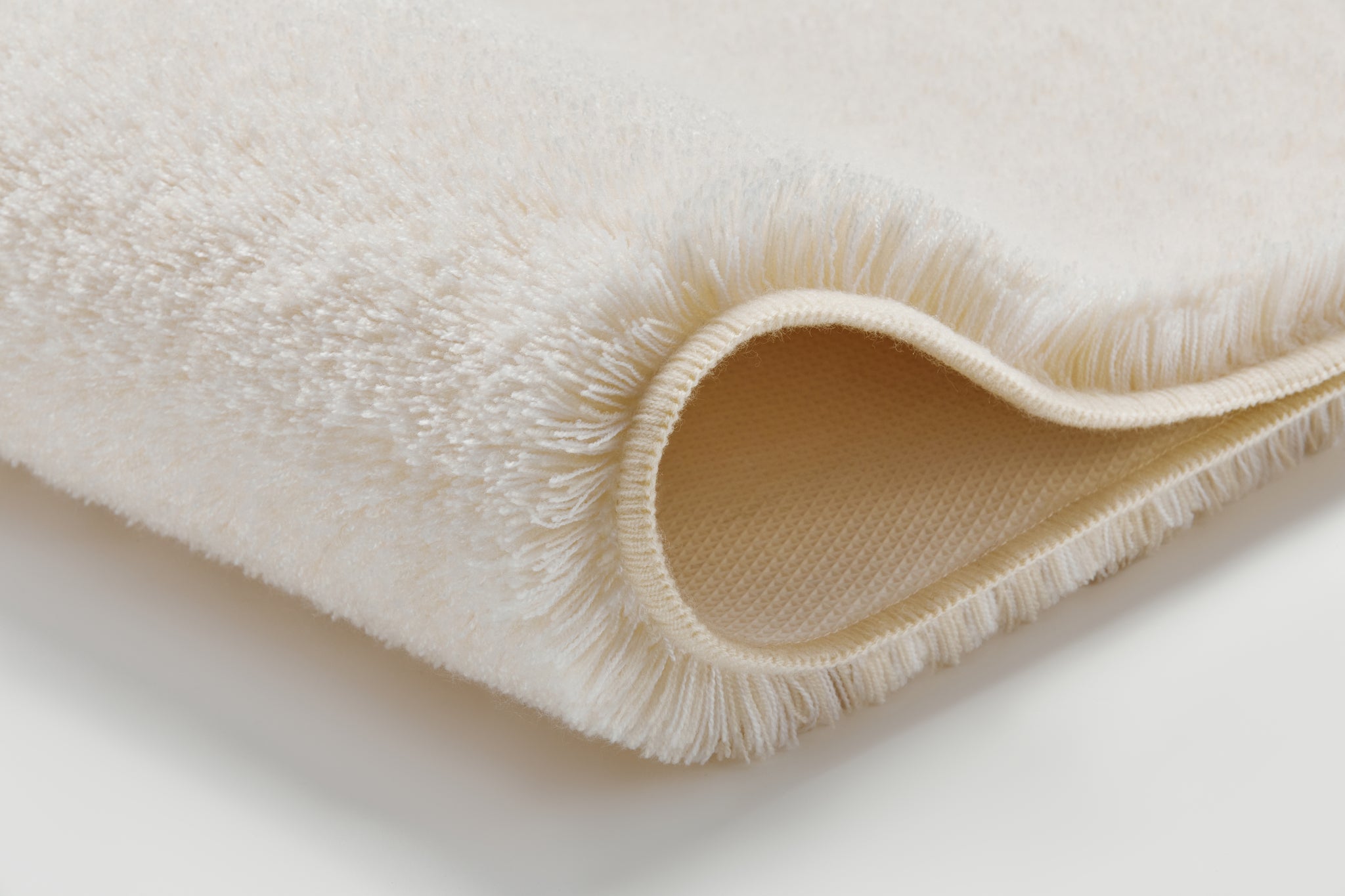 Badteppich RELAX sandbeige 60 x 100 cm liegt gefaltet und zeigt seine weiche, dichte Struktur.