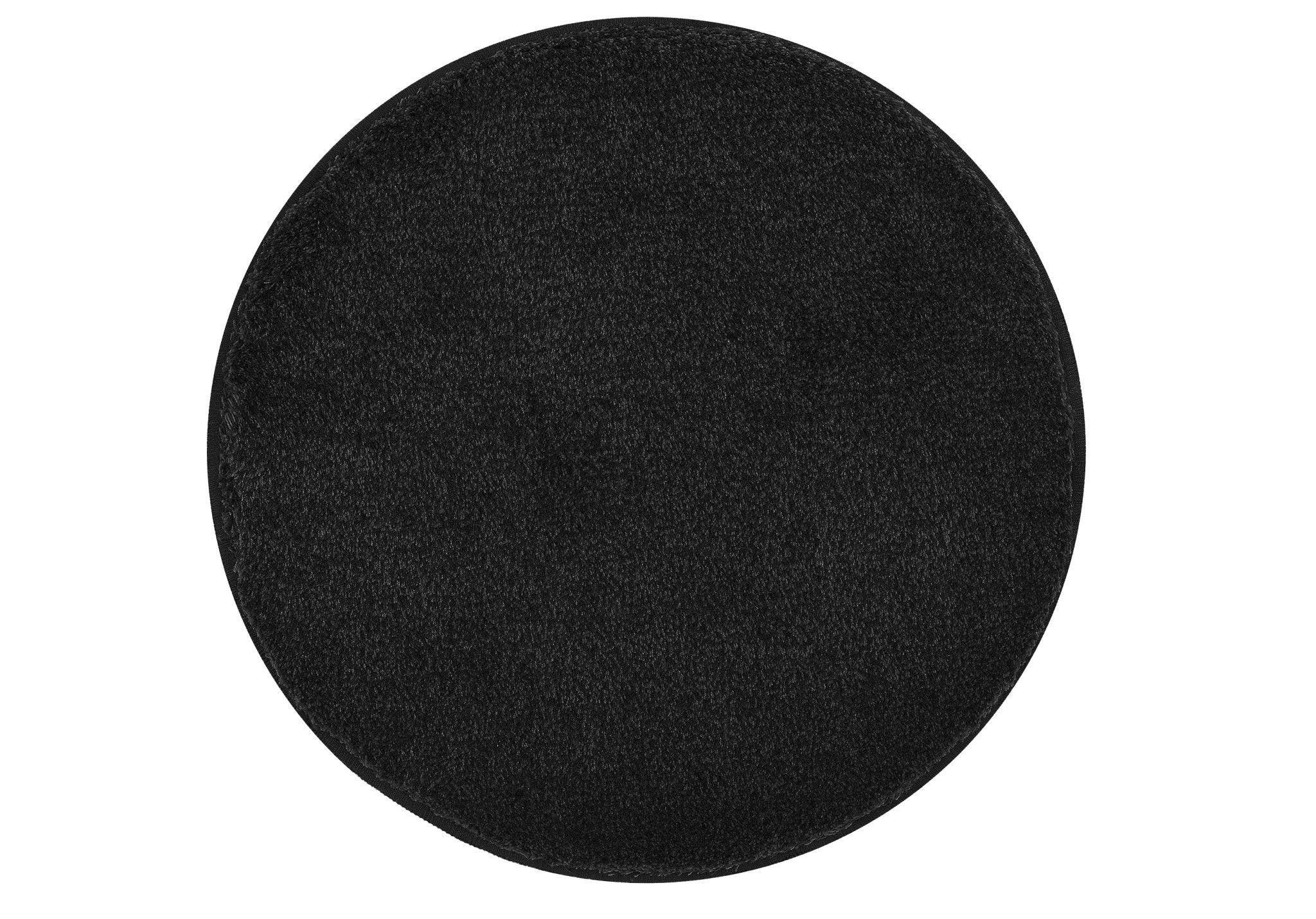 Runder schwarzer Badteppich RELAX mit 100 cm Durchmesser liegt auf hellem Untergrund.