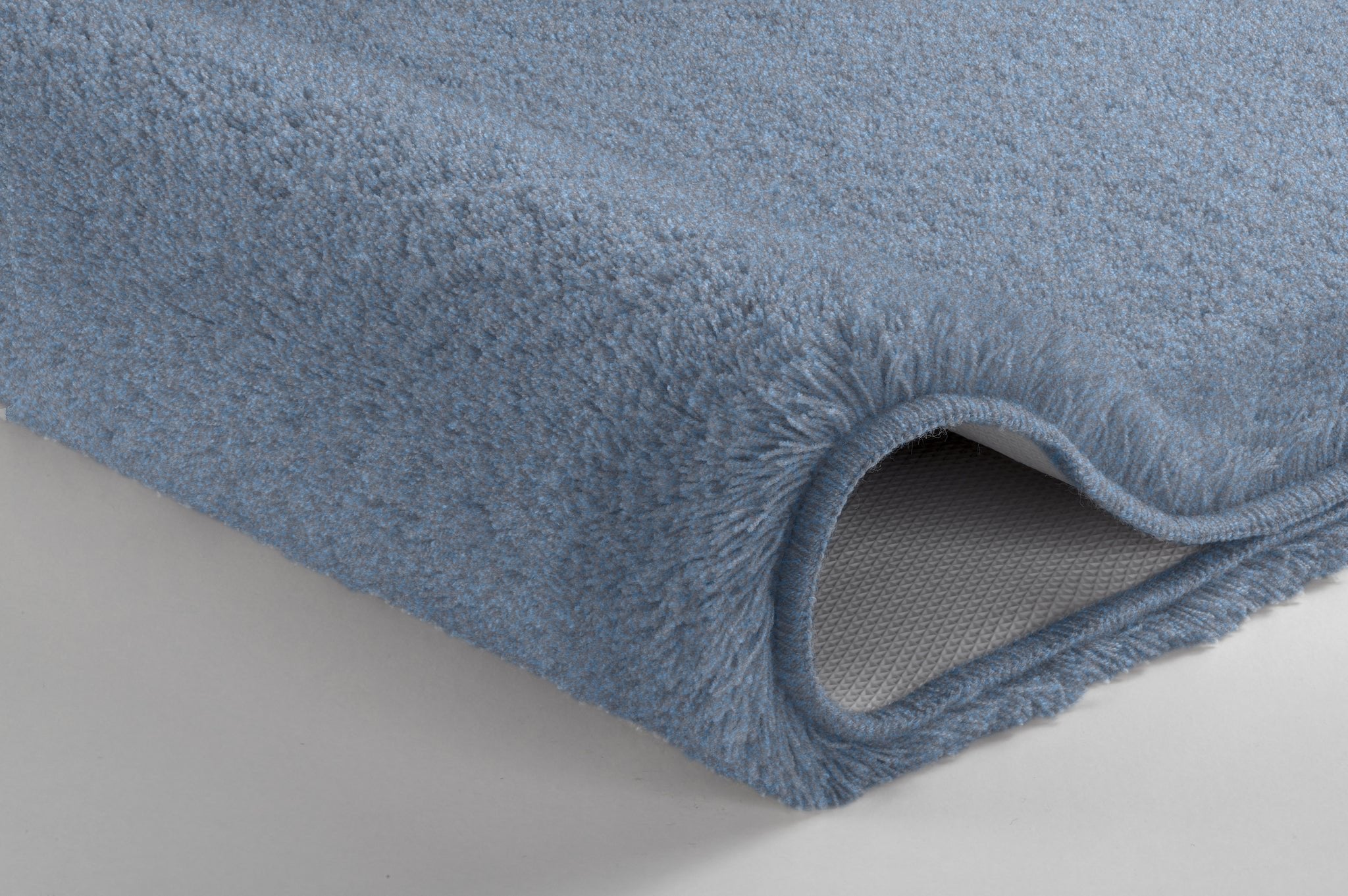 Nahaufnahme einer hellblauen Badematte mit weichem, dichtem Flor