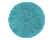 Ein runder, hochfloriger Teppich in Türkis liegt vollständig ausgebreitet auf hellem Untergrund.